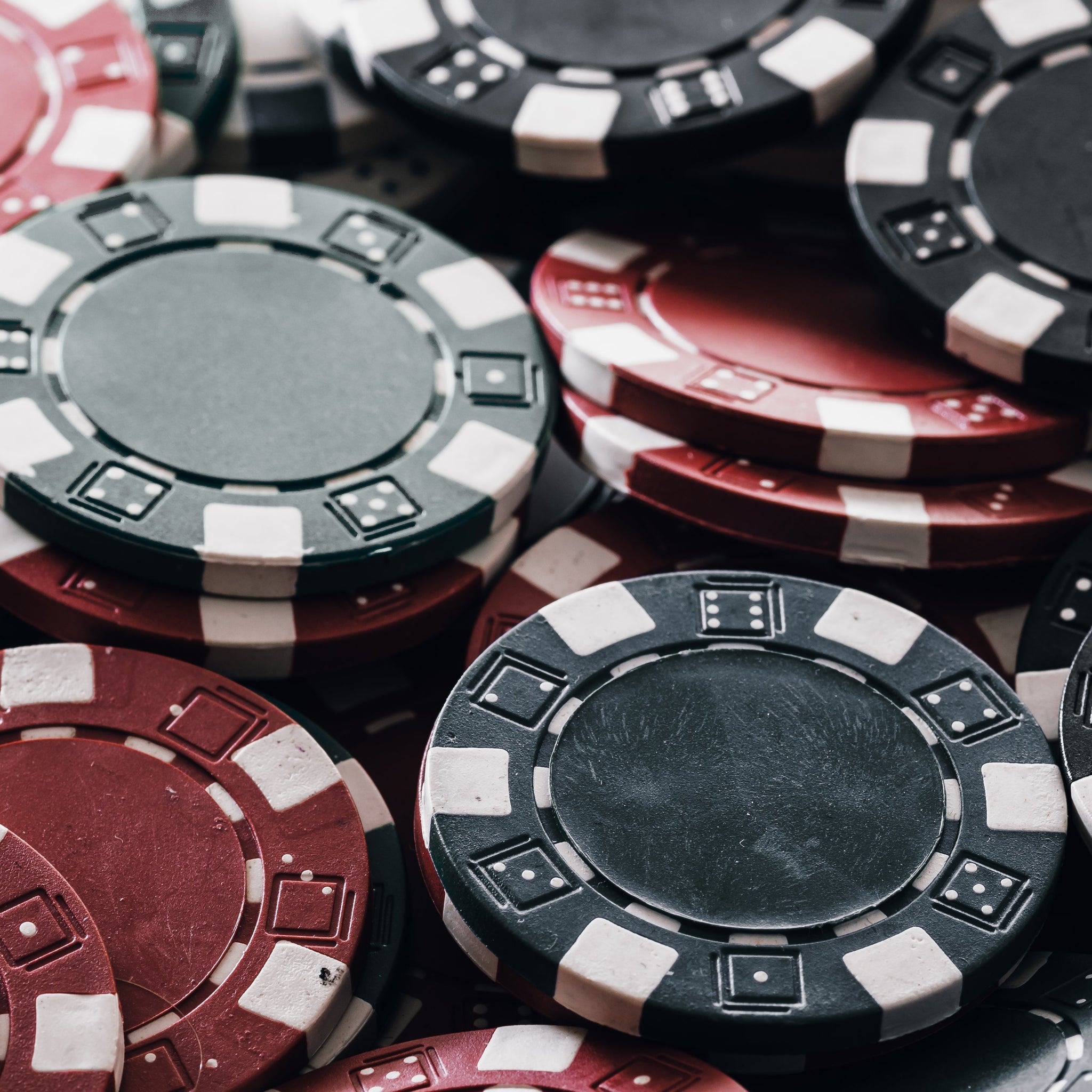 A stacked poker chip set featuring red, black, and green gambling chips, commonly used as casino chips and game chips for home games and poker table setups. | MRC Poker
